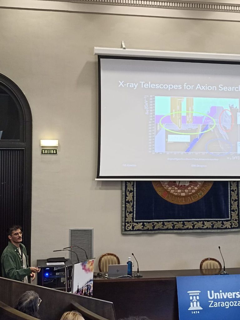 Francisco giving a talk titled X-ray telescopes for axion searches in a university hall